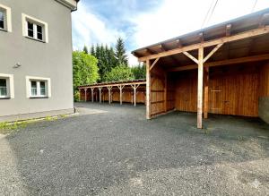 a large building with a wooden covering next to a building at Apartmán Jizerské údolí in Kořenov +1 photo
