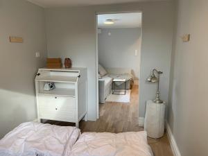 a bedroom with a bed and a dresser and a mirror at Central guesthouse in Halmstad