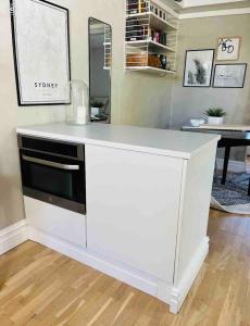 a kitchen with a white counter with a microwave at Central guesthouse in Halmstad