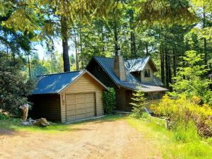 a small house with a garage in the woods at Coastal Cabin above the Clouds in Brookings