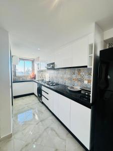 a kitchen with white cabinets and a black refrigerator at بوابة الشمس 2 in Agadir