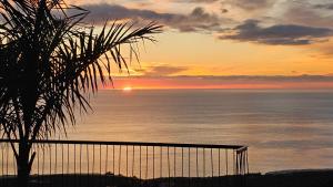 a sunset over the ocean with a palm tree at CASA LAINA - Piscina Climatizada in Tijarafe