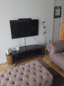 a living room with a couch and a flat screen tv at 2 Bedroom APARTMENT in Manchester