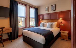a bedroom with a bed and a desk and a window at Brewhouse & Kitchen - Bournemouth - Southbourne in Bournemouth