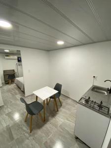 ein Zimmer mit Tisch und Stühlen und einer Küche in der Unterkunft Edificio Cardamomo in Neiva