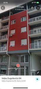 a red building with balconies on the side of it at Roza in Ruma