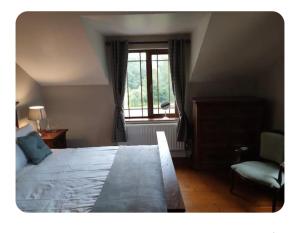 a bedroom with a bed and a window and a chair at Dairy Guesthouse in Cappamore