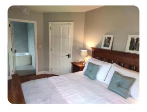 a bedroom with a large white bed with two pillows at Dairy Guesthouse in Cappamore
