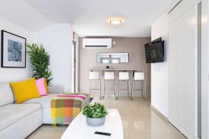 a living room with a couch and a table at AQUA Ville Moderna - Serene 16BR Coastal Haven Villa with Pool in Dorado