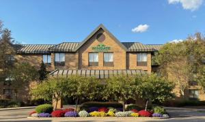 a building with flowers in front of it at Wingate by Wyndham Utica in Utica