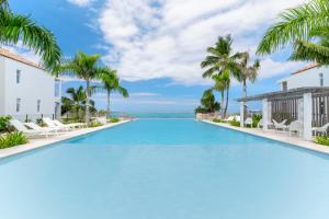 a large swimming pool in a resort with palm trees at Paradise luxury White Beach in Paea