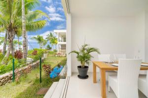 a dining room with a table and palm trees at Paradise luxury White Beach in Paea +10 photos