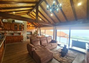 a living room with a couch and a large window at O Palheiro in Caramulo