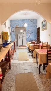 a dining room with tables and a white refrigerator at Pousada A CASA DE IRENE in Aparecida