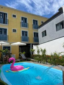 a pink swan in a swimming pool next to a building at Pousada VilaZinha in Vila Velha