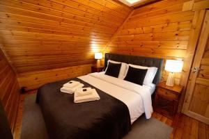 a bedroom with a large bed in a wooden cabin at Chalet O Refúgio 1 in Penhas da Saúde