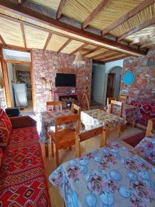 a living room with tables and a stone wall at Anar Surf House - Hostel & Private room's in Mirleft