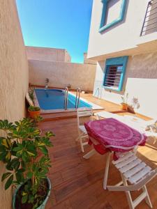 a patio with a table and chairs and a pool at Anar Surf House - Hostel & Private room's in Mirleft