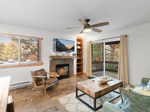 a living room with a fireplace and a ceiling fan at Red Pine Condominiums by All Seasons Resort Lodging in Park City