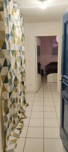 a room with a hallway with a tiled floor at T2 Voltaire in Bègles