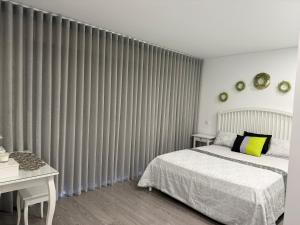 a bedroom with a bed and a window with curtains at SeaHorse House in Esposende +19 photos