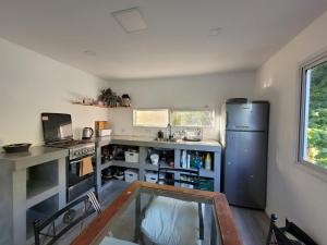 a kitchen with a stainless steel refrigerator and a table at Quinta con pileta y quincho in Fátima