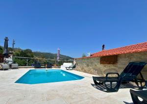 a villa with a swimming pool and two chairs at O Palheiro in Caramulo