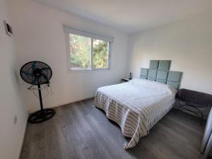 a bedroom with a bed and a window and a fan at Quinta con pileta y quincho in Fátima +14 photos