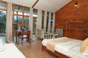 a bedroom with two beds and a table and chairs at Hotel YAN Residency Bhimtal - Nainital in Bhīm Tāl