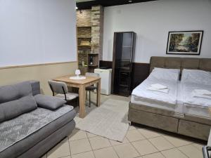 a bedroom with a bed and a table and a couch at Niš Residence in Niš