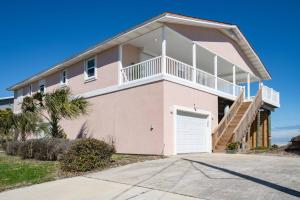 a large pink house with a garage at High Tide Paradise in St. Augustine