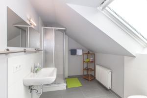 a white bathroom with a sink and a mirror at Ferienapartments Pirna in Pirna