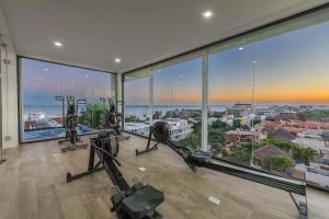an image of a gym with gym equipment and large windows at Central Studio - Rooftop Pool Gym Near Beach in Playa del Carmen