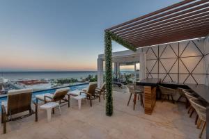a patio with a view of the ocean at Central Studio - Rooftop Pool Gym Near Beach in Playa del Carmen
