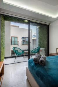 a bedroom with a bed and a balcony with chairs at Central Studio - Rooftop Pool Gym Near Beach in Playa del Carmen +11 photos