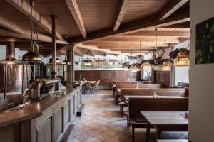 a restaurant with wooden tables and benches and a bar at Stanglbräu in Hausen +20 photos