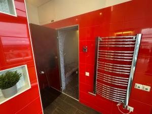 a red bathroom with a shower and a red wall at Grand Penthouse And SPA in Riga +16 photos