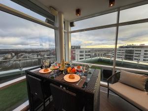a dining room with a table and views of a city at Grand Penthouse And SPA in Riga