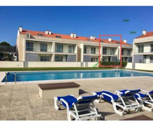 a group of chairs and a table in front of a pool at SeaHorse House in Esposende