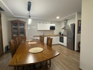 a kitchen and dining room with a wooden table and chairs at Apartamentos Rurales Sariar in Villar