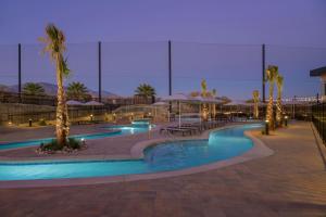 a swimming pool with palm trees and umbrellas at night at Residence Inn by Marriott St. George in Washington
