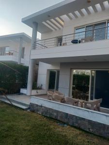 a house with chairs and tables in front of it at Sky Star Villa 97 in Hurghada