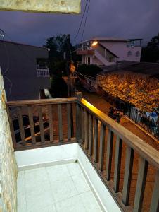a balcony with a wooden railing and a street at night at Glamar Apartamento in Arboletes