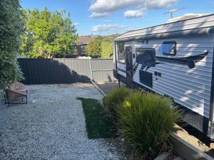 an rv parked in a gravel lot next to a fence at Modern 4 Berth Van close to CBD in Newstead