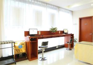 un bureau avec un bureau, un ordinateur et des chaises dans l'établissement Hanting Hotel Fuzhou Wuyizhong Road, à Fuzhou