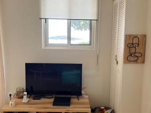 a television sitting on a table under a window at Le joyau de Pinel in Saint Martin