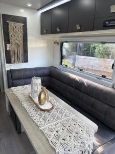 a living room with a table and a couch at Modern 4 Berth Van close to CBD in Newstead +11 photos