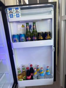 an open refrigerator filled with bottles of beer and drinks at Modern 4 Berth Van close to CBD in Newstead