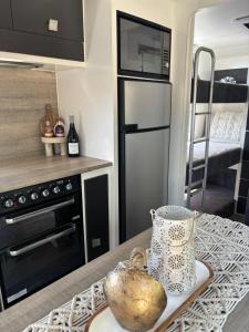 a kitchen with a refrigerator and a table with a bowl at Modern 4 Berth Van close to CBD in Newstead