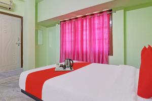 a bedroom with a white bed with a red blanket at Hotel O Ss Delight in Hyderabad +20 photos